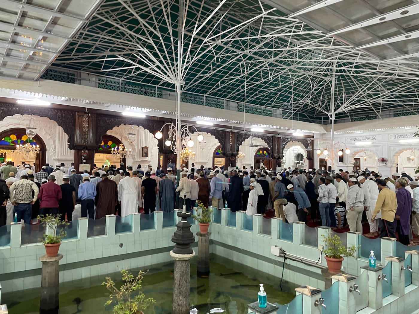 Worshippers gathered around the fish pond in the courtyard of Jummah Masjid